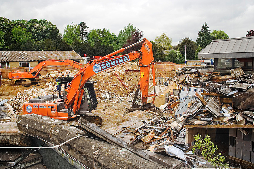 002 Knocking down more walls 
 Keywords: Aerial, building site, clearance, demolition, from the air, construction, Cirencester, contractor, digger, JCB, hard hat, protective clothing, rubble, black and white, machinery, safety,